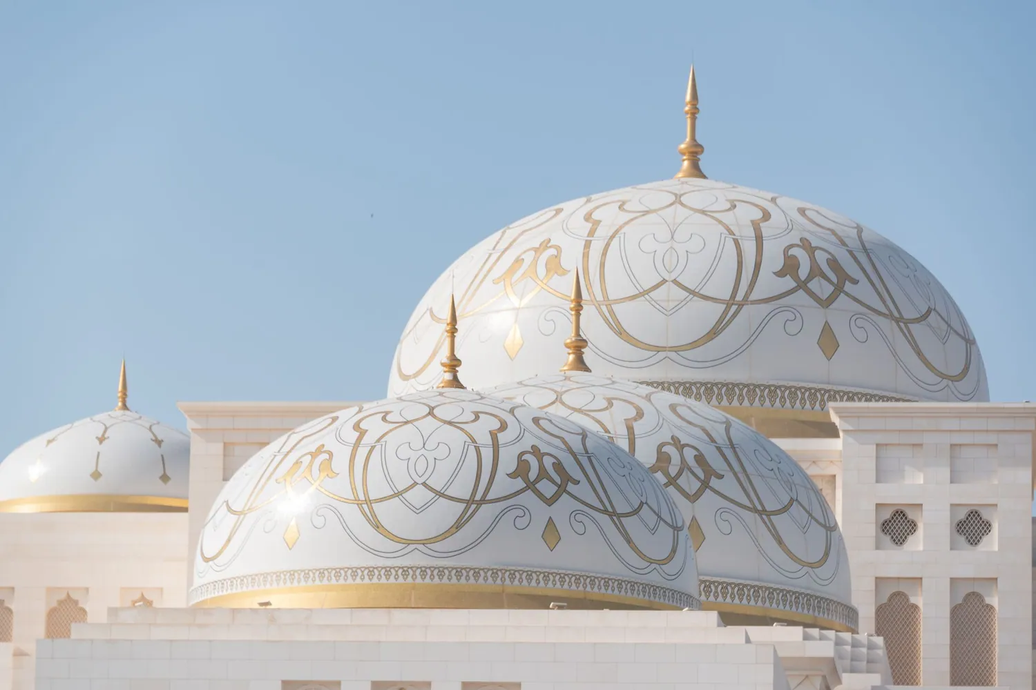 Qasr Al Watan presidential palace in Abu Dhabi, its white domes gleaming under a clear blue sky