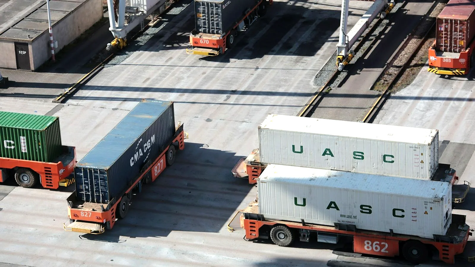 Aerial view of shipping containers and trucks at a logistics terminal