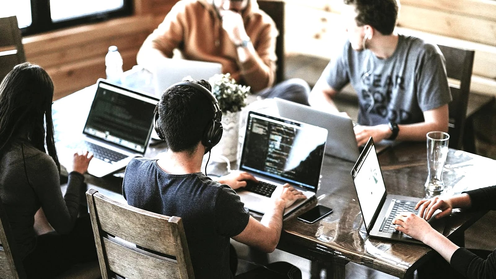 A team working together on laptops in a bright collaborative workspace